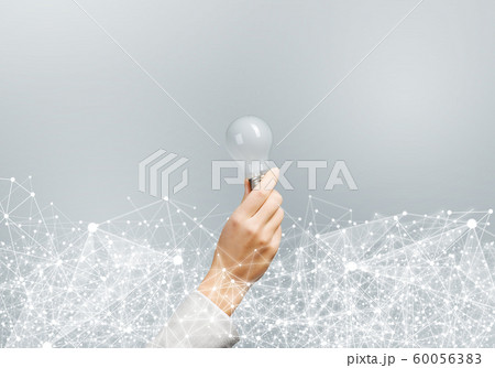 Woman hand holding light bulb and abstract network Woman hand holding light bulb and abstract network 60056383