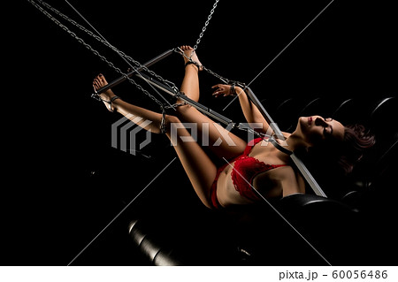 Girl in red lingerie fixed with bdsm chain view - Stock Photo