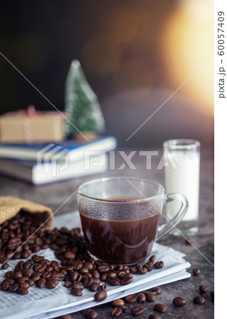 a cup of hot espresso coffee drink with smoke and roasted coffee beans on the table in the morning. vertical image, cropped shot a cup of hot espresso coffee drink with smoke and roasted coffee beans on the table in the morning. vertical image, cropped shot 60057409