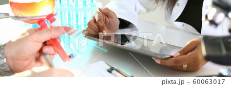 A male chemist holds test tube of glass 60063017