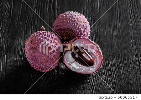 three lychees on a dark wooden background 60065517