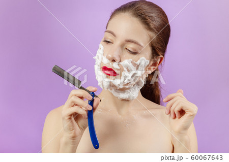 woman shaves her face woman shaves her face 60067643