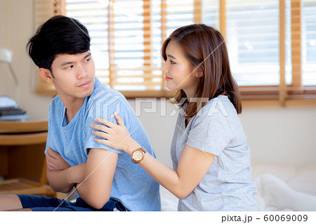Young asian couple a problem and woman ask forgive and sorry with man feeling angry at bedroom 60069009