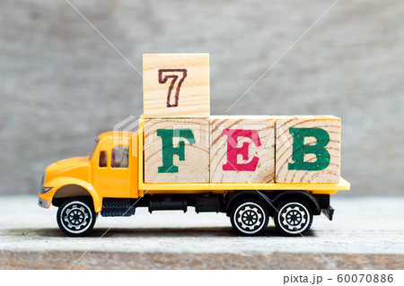 Truck hold letter block in word 7feb on wood background Truck hold letter block in word 7feb on wood background 60070886