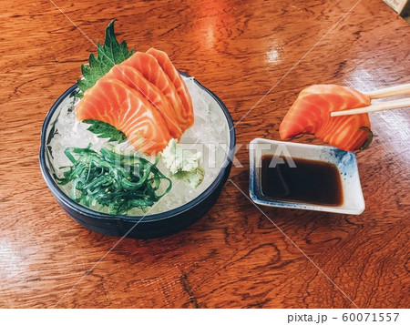 Salmon sashimi in an ice-filled cup with wasabi seaweed and shoyu sauce 60071557