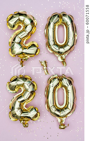 Happy New year 2020 celebration. Gold foil balloons numeral 2020 and golden stars on pastel pink 60071558