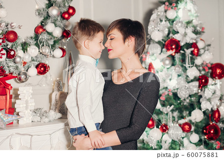 Happy parents showing Christmas decoration on tree 60075881