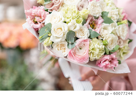 European floral shop. Beautiful bouquet of mixed flowers in womans hands. the work of the florist at 60077244