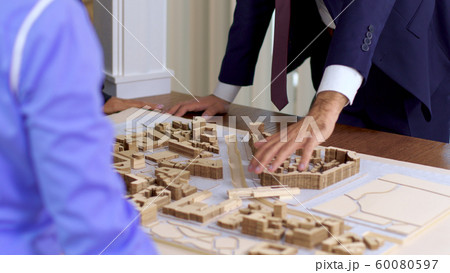 Young architect in business suit explaning his new construction project Young architect in business suit explaning his new construction project 60080597