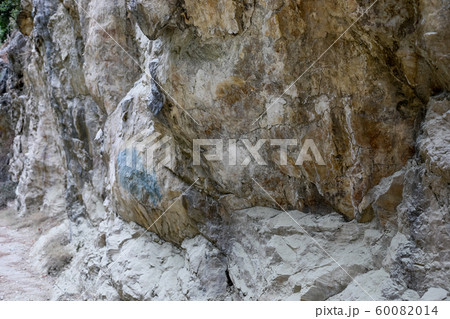 Huge massive natural textured grey-brown stone wall with uneven surface as background or wallpaper. Huge massive natural textured grey-brown stone wall with uneven surface as background or wallpaper. 60082014