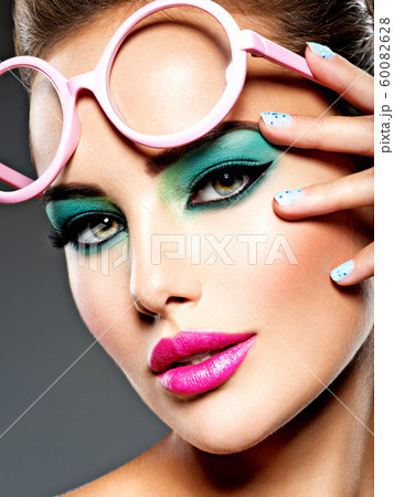 Beautiful Face of a woman with green vivid make-up 60082628