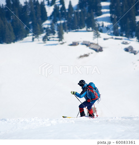 Skier hiker with backpack on skis in deep white snow on background of beautiful winter landscape. Skier hiker with backpack on skis in deep white snow on background of beautiful winter landscape. 60083361