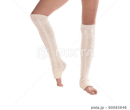 Female slim legs in white leg warmers. Barefooted woman stands in dancers position, classic pedicure, isolated. 60083646