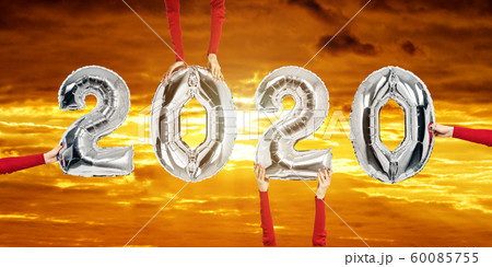 Number 2020 of silver balloons in female hands. Number 2020 of silver balloons in female hands. 60085755