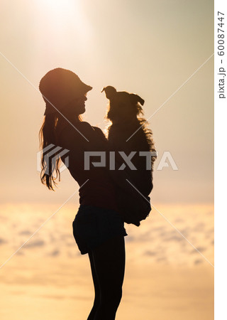 Silhouette of girl with puppy on sunset 60087447