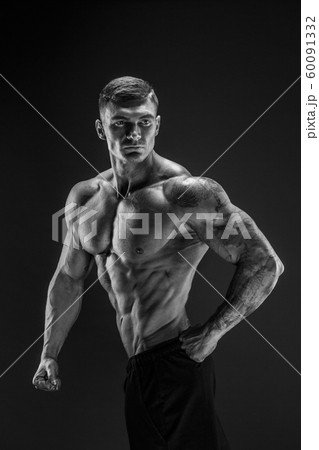 Bodybuilder posing. Fitness muscled man on dark background. Bodybuilder posing. Fitness muscled man on dark background. 60091332
