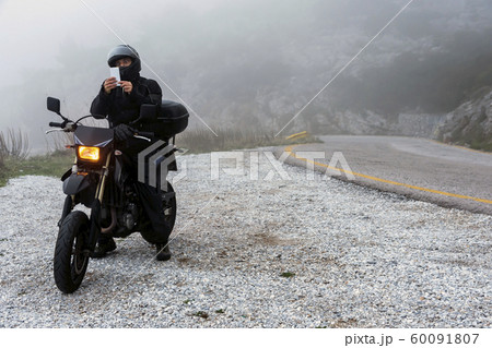 Rider is trying to find signal on his mobile on a Rider is trying to find signal on his mobile on a 60091807