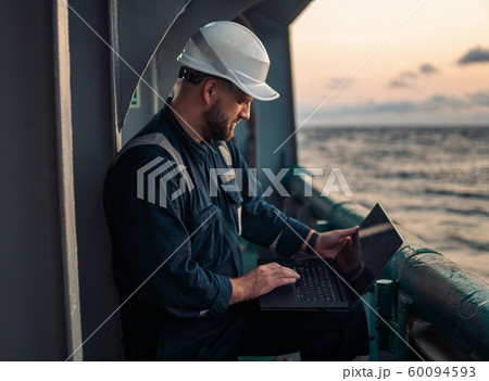 Marine chief officer or captain on deck of vessel or ship watching laptop Marine chief officer or captain on deck of vessel or ship watching laptop 60094593