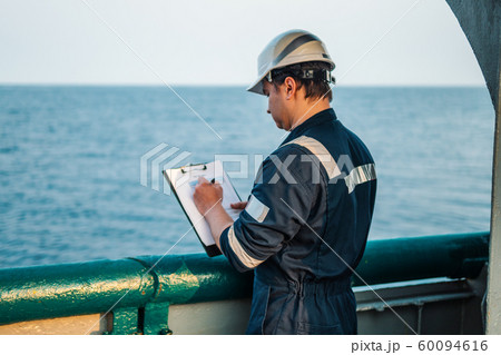 Deck Officer on deck of offshore vessel or ship , wearing PPE personal protective equipment. He 60094616