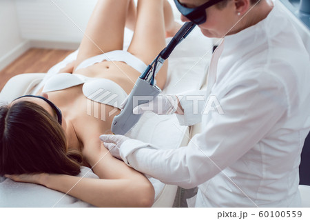 Woman during hair removal using modern laser technology 60100559