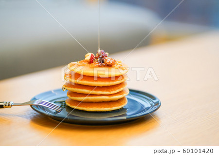 はちみつを垂らすパンケーキの写真素材