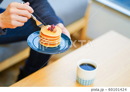 パンケーキを食べる男性の手の写真素材