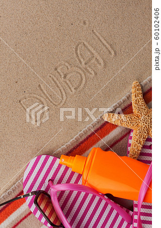 Word DUBAI written in sand with beach accessories. Word DUBAI written in sand with beach accessories. 60102406