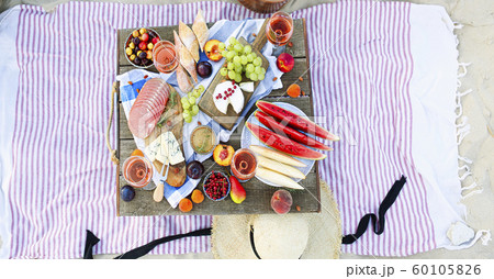 Picnic on the beach at sunset in the style of boho 60105826