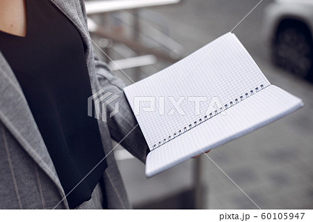 Elegant businesswoman working in a city and use the notebook 60105947