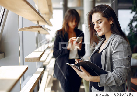 Two businesswomen working in a cafe Two businesswomen working in a cafe 60107296