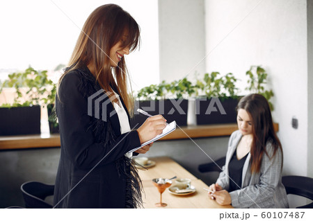 Two businesswomen working in a cafe 60107487