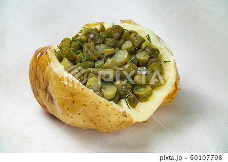 Photo of baked potato with gherkins filling on white background 60107798