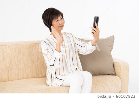 シニア女性 スマートフォン ビデオ通話 シニア女性 スマートフォン ビデオ通話 60107922