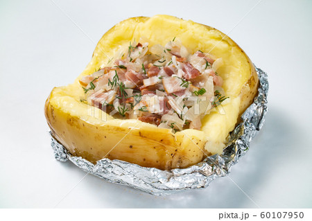 Baked potato with bacon filling on white background Baked potato with bacon filling on white background 60107950