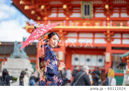 Geishas girl wearing Japanese kimono among red Geishas girl wearing Japanese kimono among red 60112024