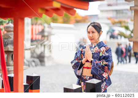 Geishas girl wearing Japanese kimono among red 60112025