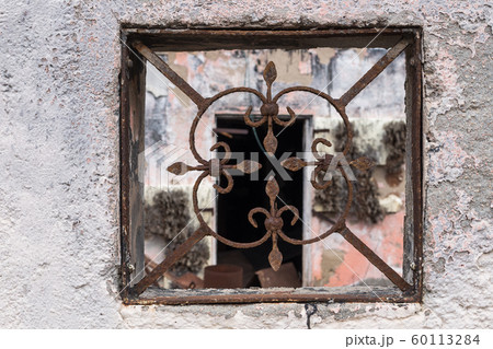 Grid in a fence of an abandoned house Grid in a fence of an abandoned house 60113284
