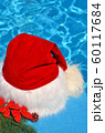 Santa Claus hat on a branch of spruce and toys. 60117684