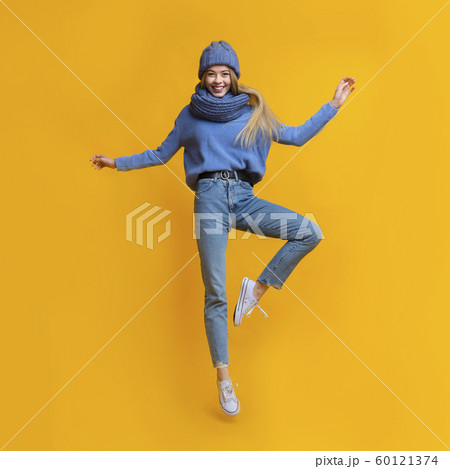Young beautiful girl in warm clothes jumping up 60121374