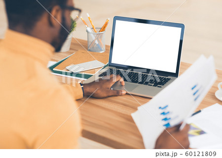 African american manager typing on lapop holding report 60121809