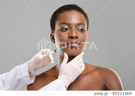 African american woman making lip augmentation procedure by doctor 60121969