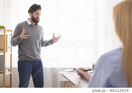 Puzzled man talking about life problems with psychologist 60122014