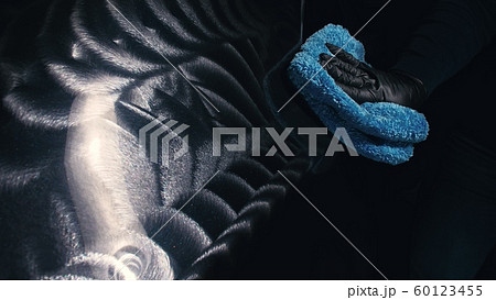 Using rag in palm of your hand, finish liquid car polish are removed from the car. Layers of cream delete from car body. Process of polishing auto. 60123455