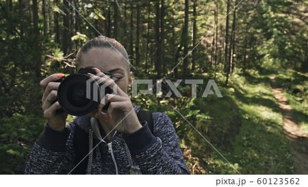 Traveler photographing scenic view in forest. One caucasian woman shooting close up look. Girl take photo video on dslr mirrorless camera. Traveler photographing scenic view in forest. One caucasian woman shooting close up look. Girl take photo video on dslr mirrorless camera. 60123562