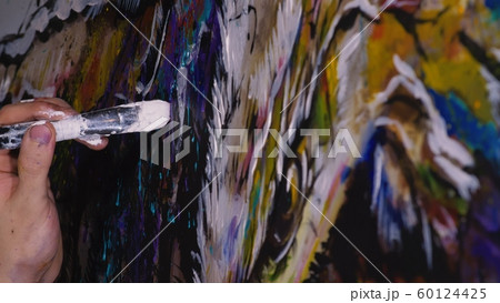 Artist designer draws an eagle on the wall. Craftsman decorator paints a picture with acrylic oil color brush. Close-up dark magic cinematic look. Artist designer draws an eagle on the wall. Craftsman decorator paints a picture with acrylic oil color brush. Close-up dark magic cinematic look. 60124425