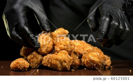 Cool beautiful fresh juicy cooked chicken wings in breading. Buffalo wings spread on food in white plate. Cooking with deep fryer fry machine. 60125001