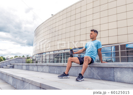sports man resting after hard workout, shaker with protein and water, a daytime workout in city, active lifestyle, modern fitness workout. Free space. sports man resting after hard workout, shaker with protein and water, a daytime workout in city, active lifestyle, modern fitness workout. Free space. 60125015