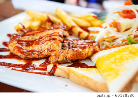 Grilled pork steak with salad on a plate Grilled pork steak with salad on a plate 60128530