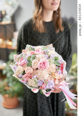 European floral shop. Beautiful bouquet in womans hands. the work of the florist at a flower shop. Delivery fresh cut flower. 60134934