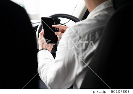 スマートフォンを操作しながら運転している男 60137803